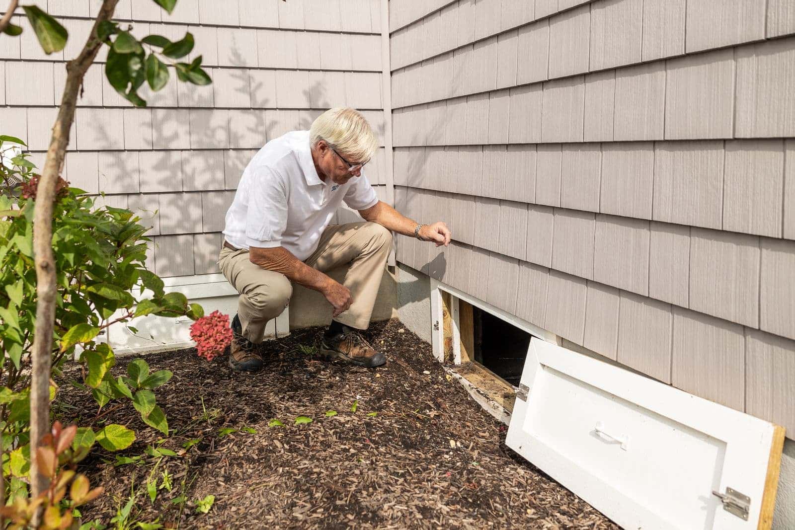 Inspector checking a crawl space access